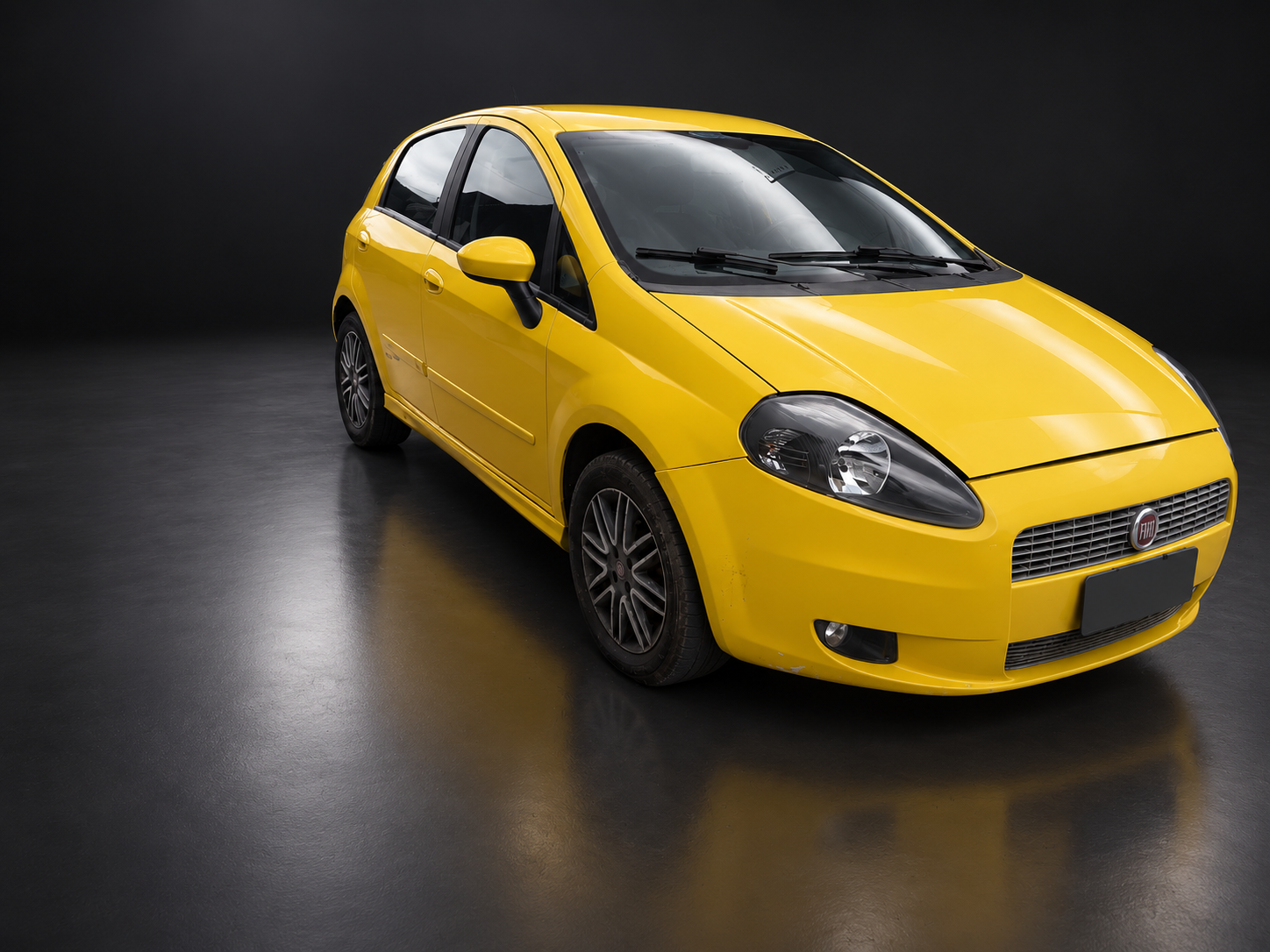 Fiat Punto amarelo em estúdio, visto de frente